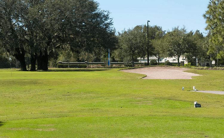 Blue flag on golf course with bunkers